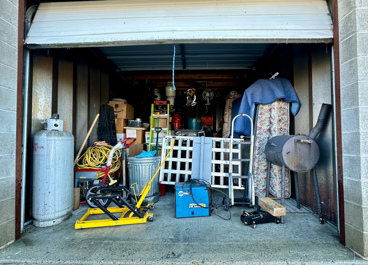 Garage packed with stored tools, boxes, and furniture before a cleanout